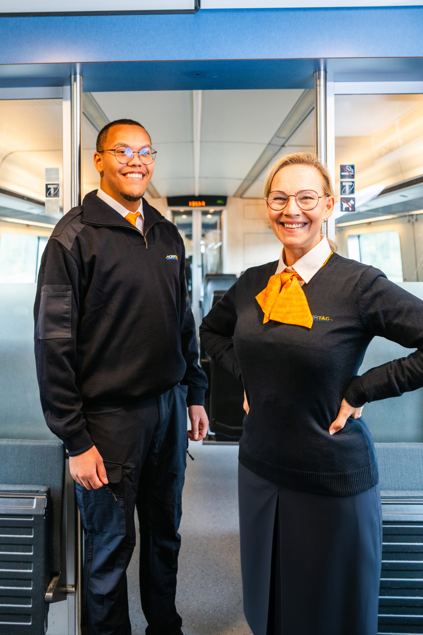 Tågvärdar med Norrtågsuniform ombord på ett tåg.